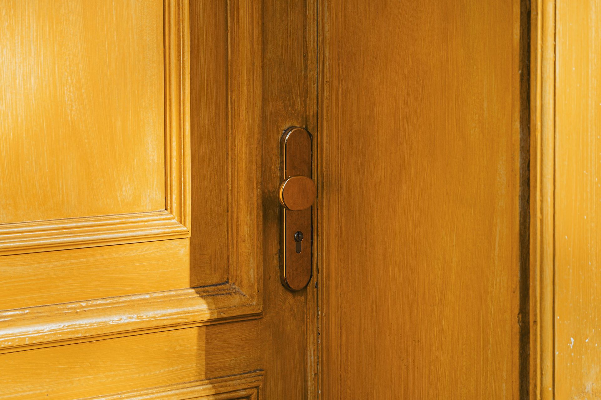 A close up of a door handle on a wooden door